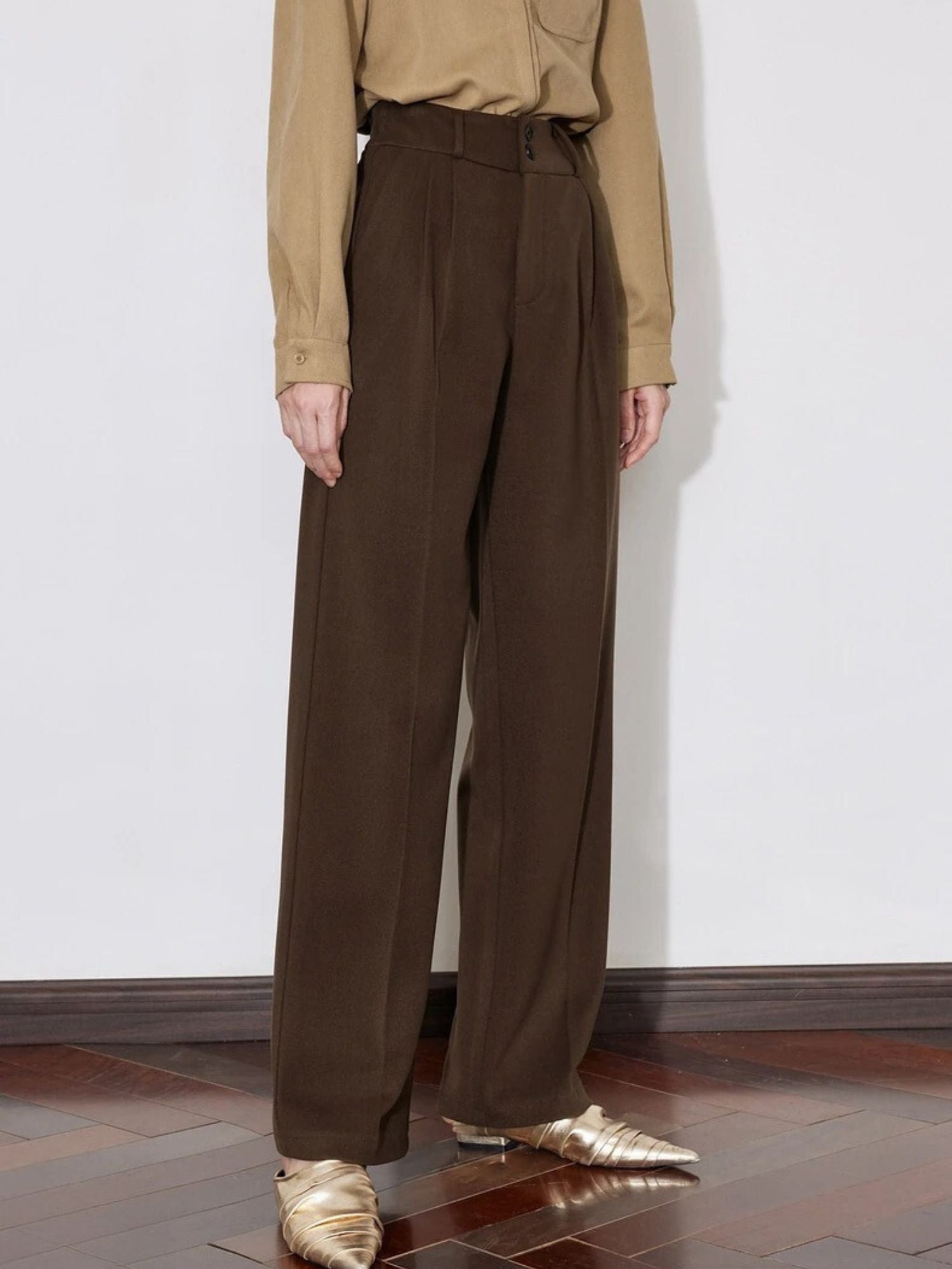 Side view of brown wide-leg trousers styled with beige sweater