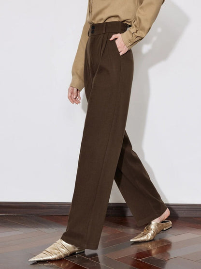 Woman in brown wide-leg trousers with beige sweater and loafers