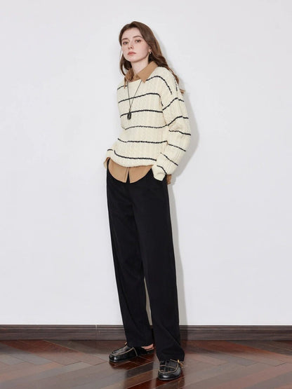 A model wearing a lose striped sweater with a pair of black lose pants