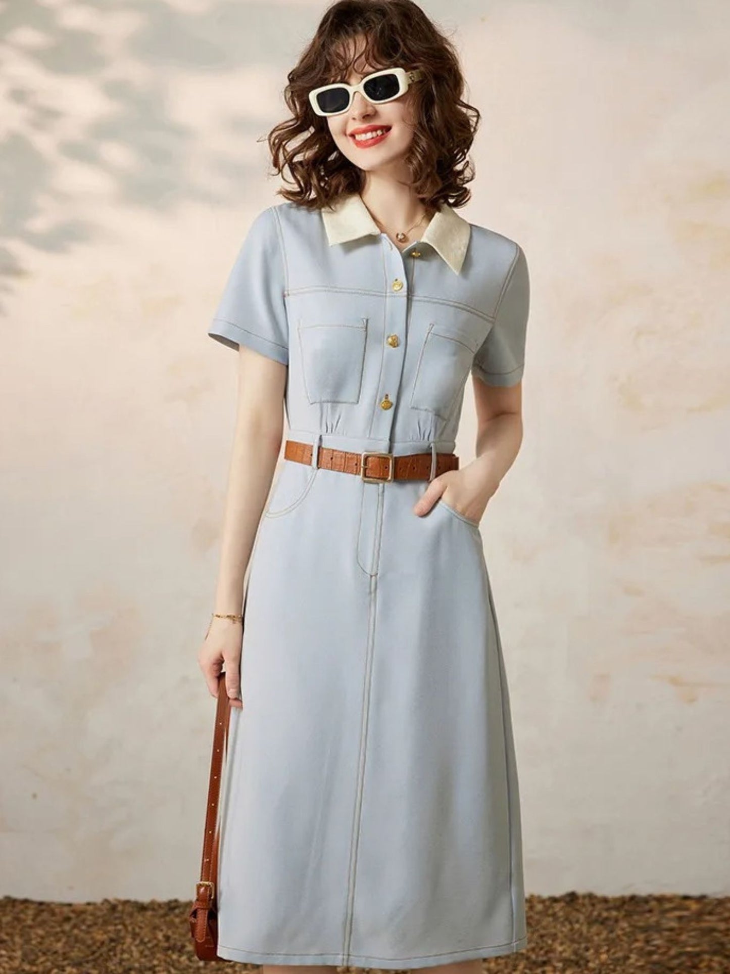 Front view of light blue dress styled with a thin brown belt