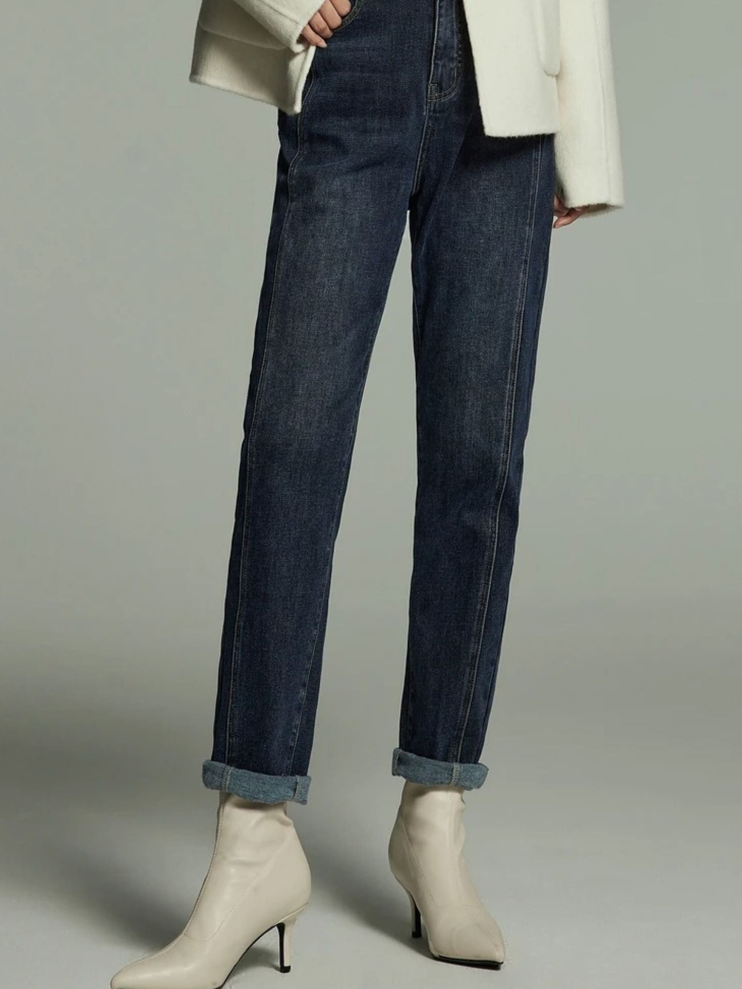 Side view of dark wash straight-leg jeans paired with ankle boots