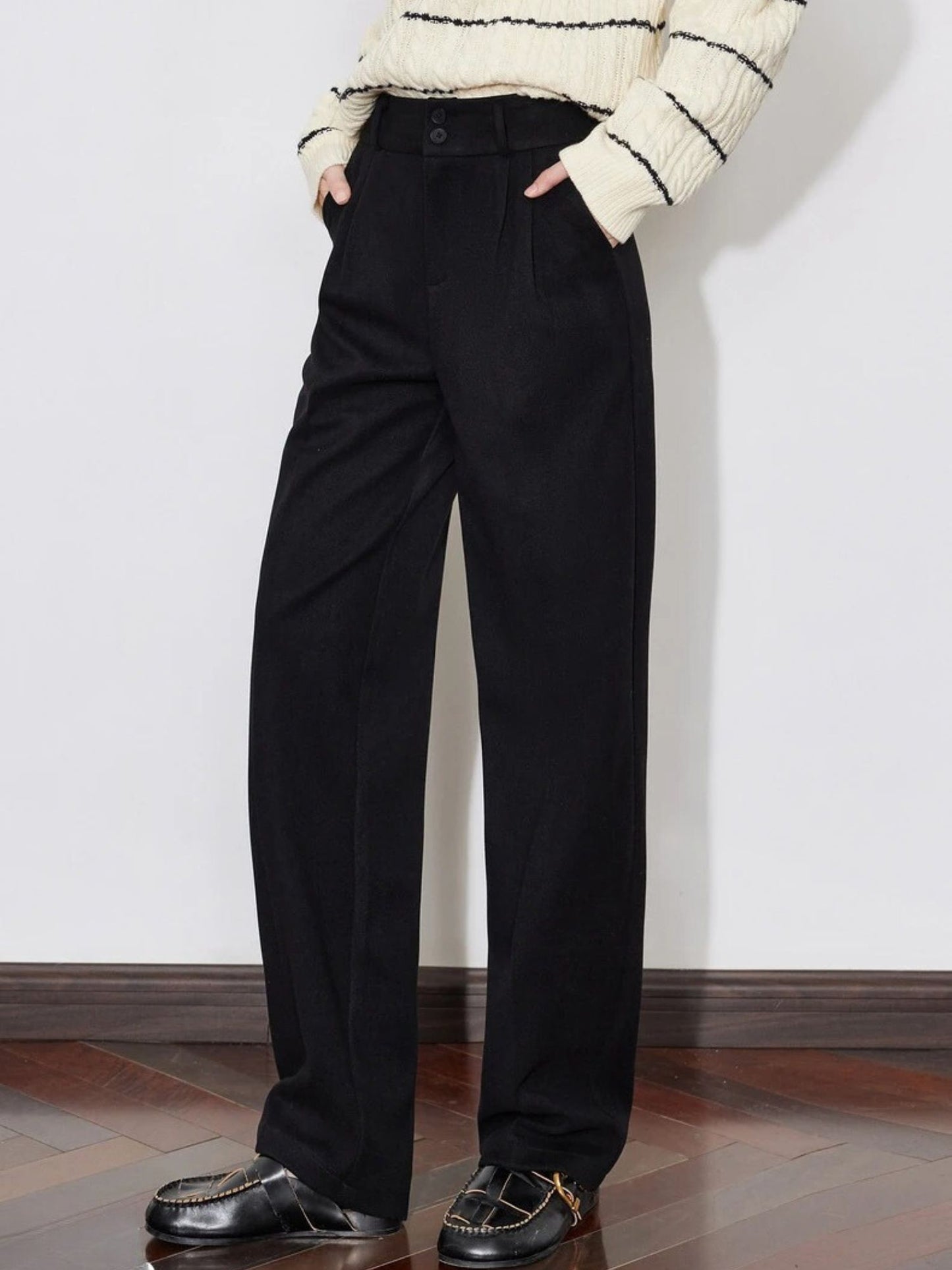 Side view of black wide-leg trousers styled with striped sweater and loafers
