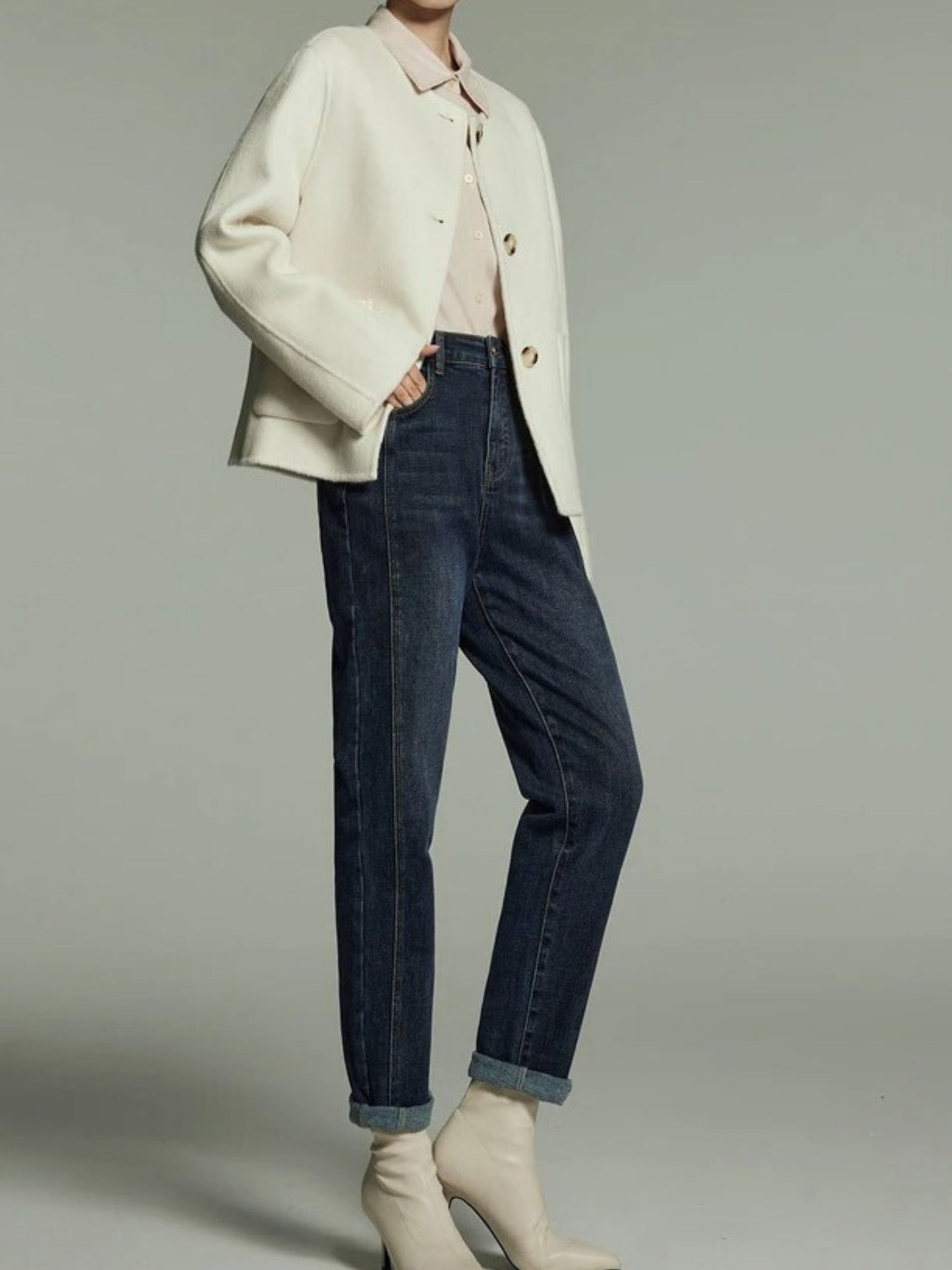 A pair of high-waisted, straight cut denim jeans with embroidered detailing, featuring a medium wash and zip fly