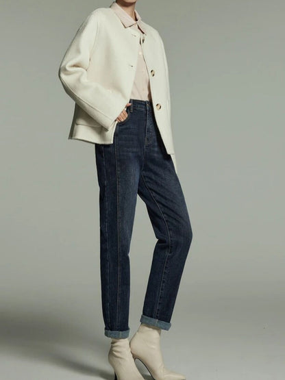 A pair of high-waisted, straight cut denim jeans with embroidered detailing, featuring a medium wash and zip fly