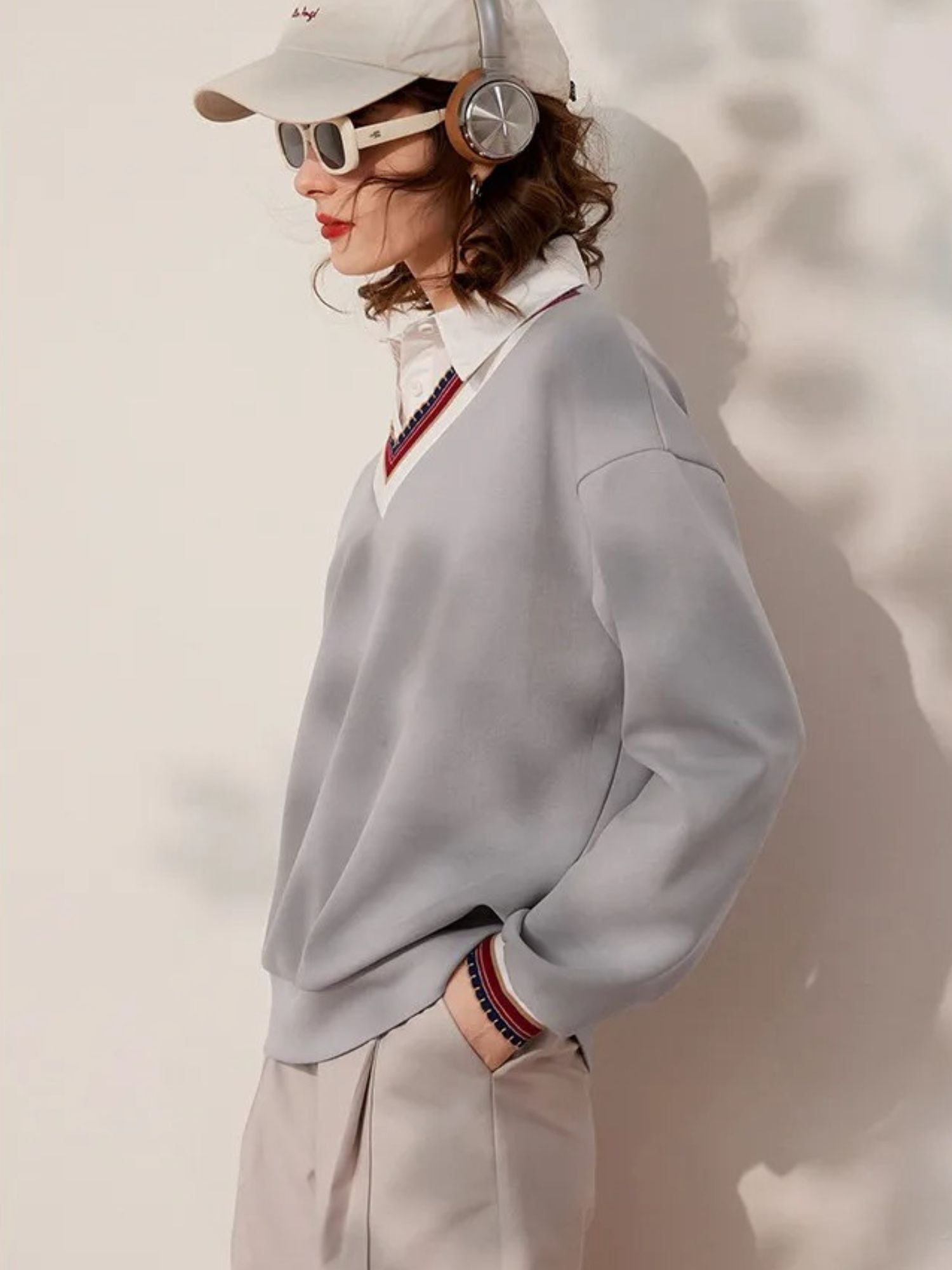 Side view of light grey V-neck sweatshirt with striped neckline