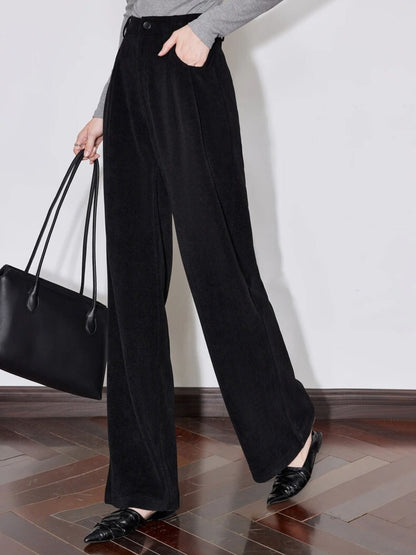 Side view of black wide-leg trousers with handbag and grey top