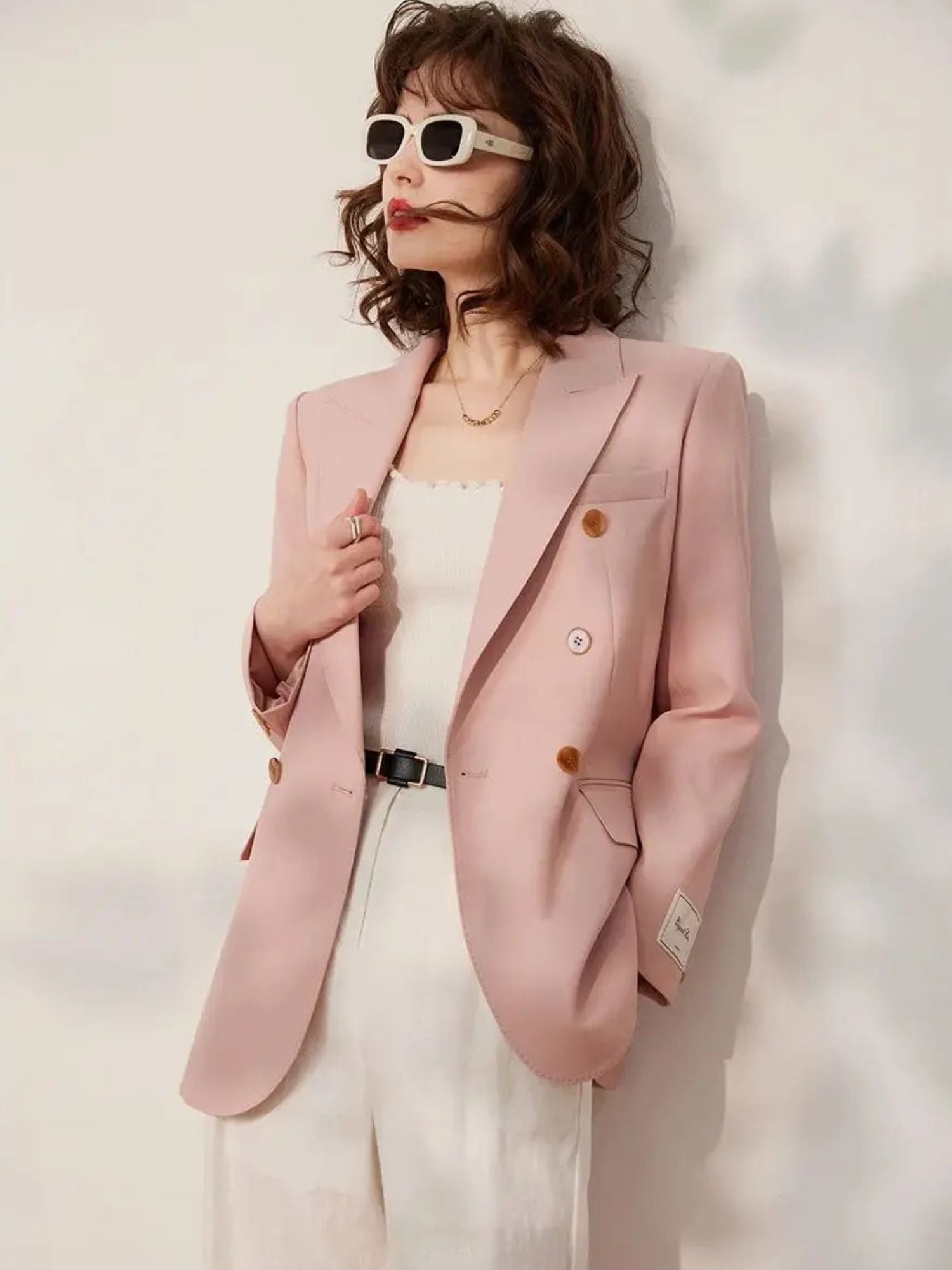 Side profile of the woman looking to the left, highlighting the structure and silhouette of the blazer
