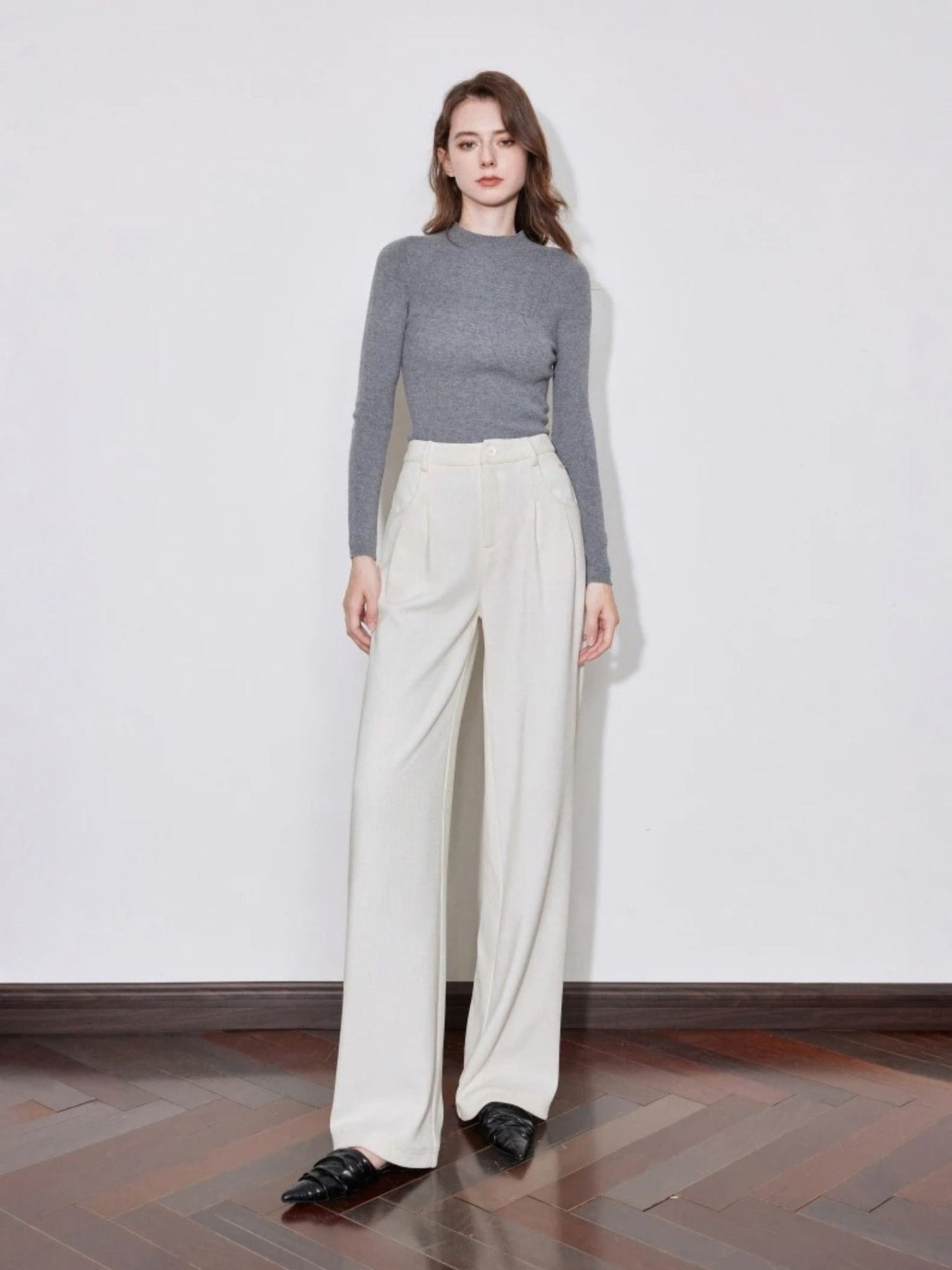 Full-body view of woman in ivory wide-leg trousers with grey long-sleeve top
