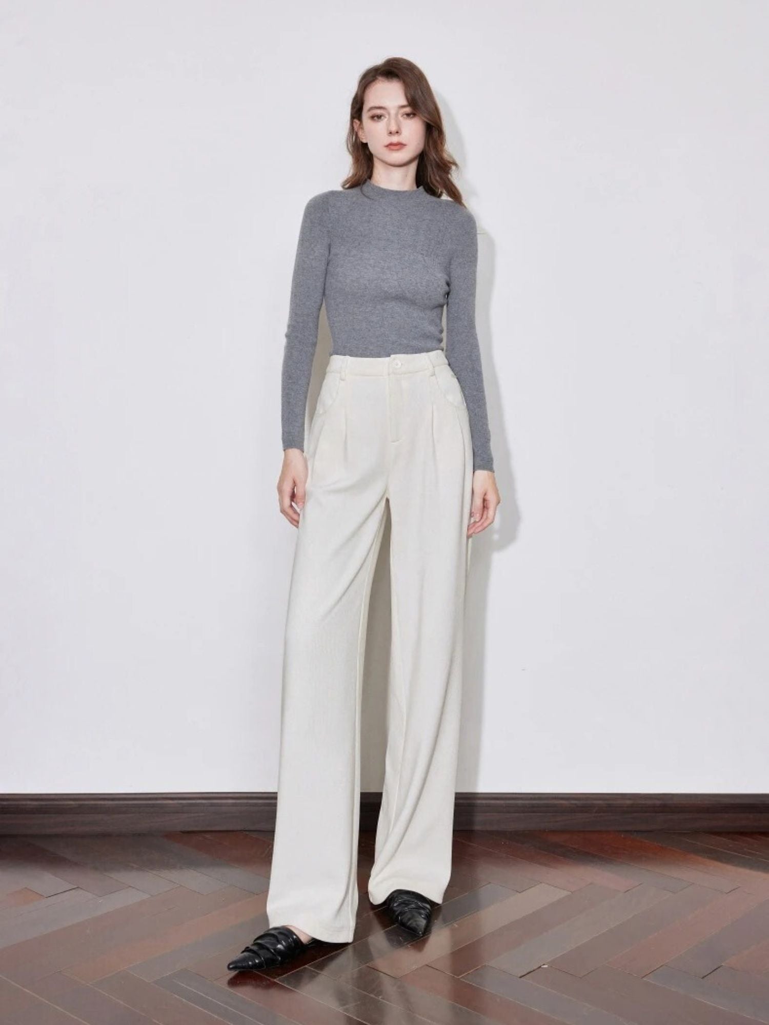 Full-body view of woman in ivory wide-leg trousers with grey long-sleeve top