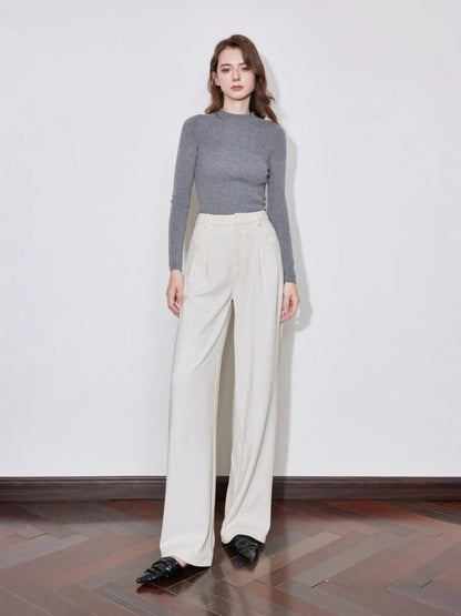 Full-body view of woman in ivory wide-leg trousers with grey long-sleeve top