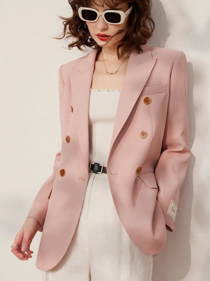 Frontal view with the blazer slightly open, showing the full outfit including the tucked-in white top and high-waisted white trousers