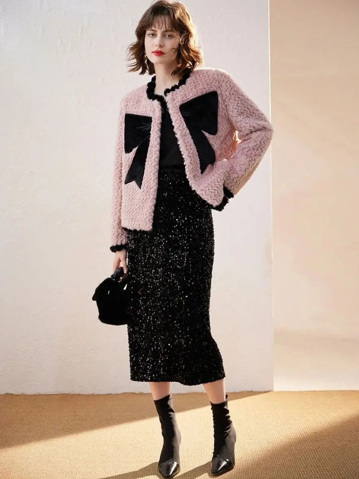 A young lady wearing a faux fur jacket with a velvet bow design