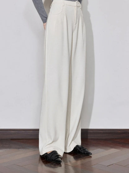 Side view of ivory wide-leg trousers styled with grey top and black shoes