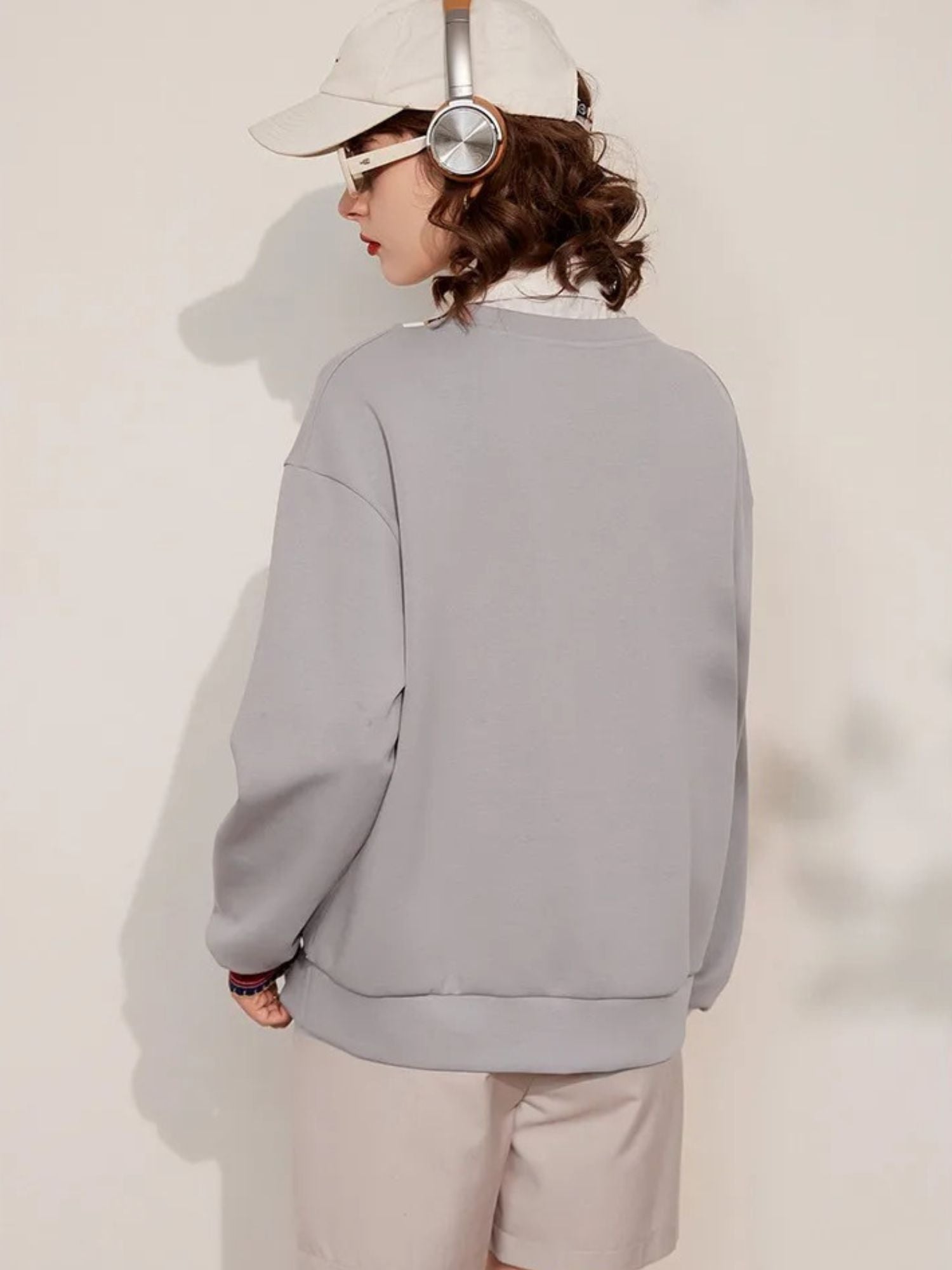 Back view of light grey V-neck sweatshirt with plain design