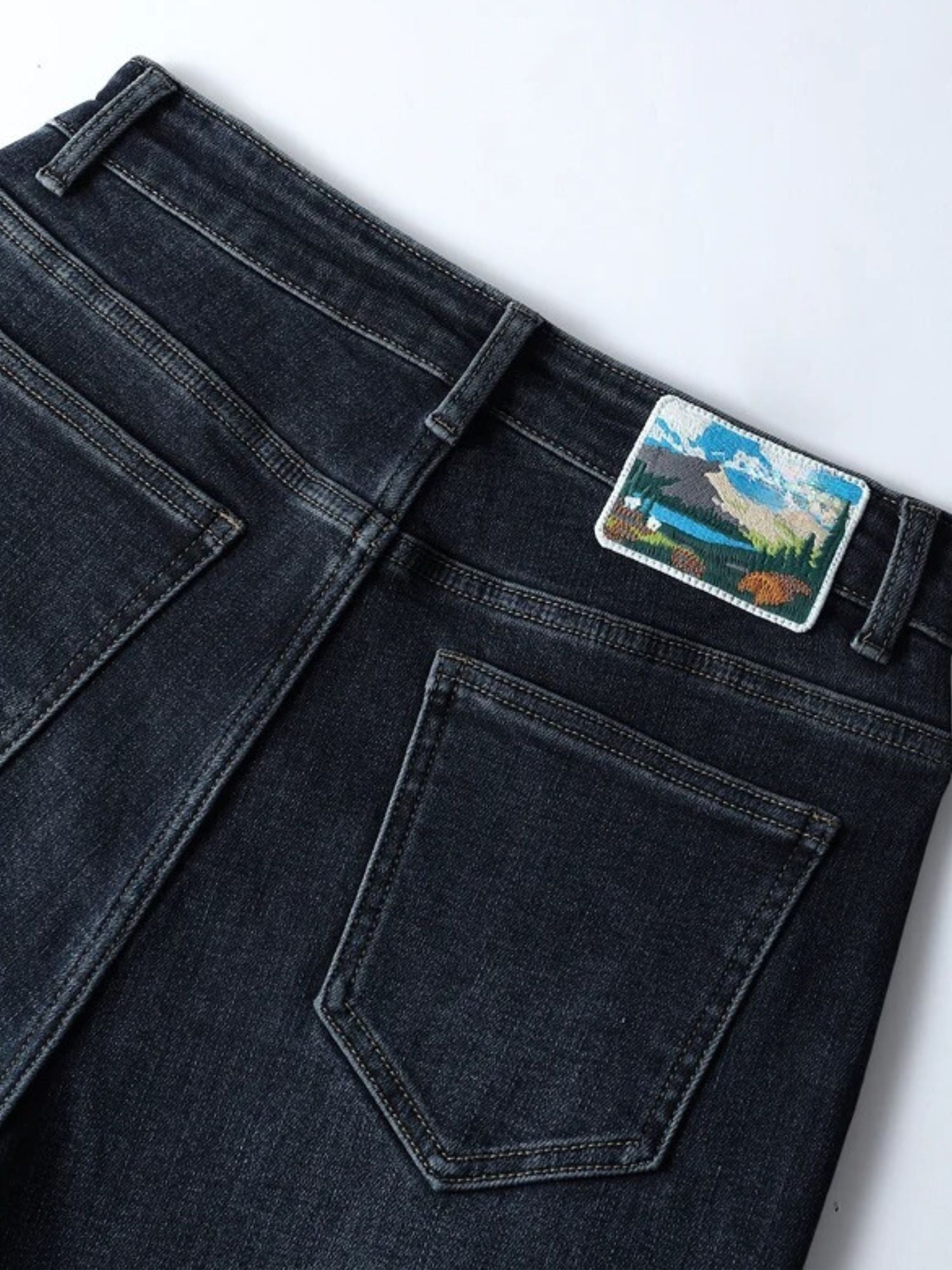 Close-up detail of dark wash jeans pocket and waistband patch