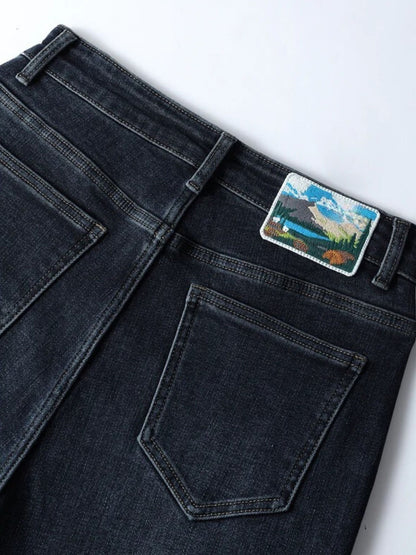 Close-up detail of dark wash jeans pocket and waistband patch