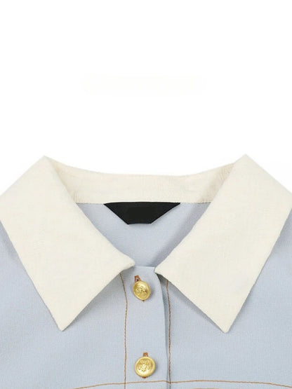 Close-up of white pointed collar and gold button detail