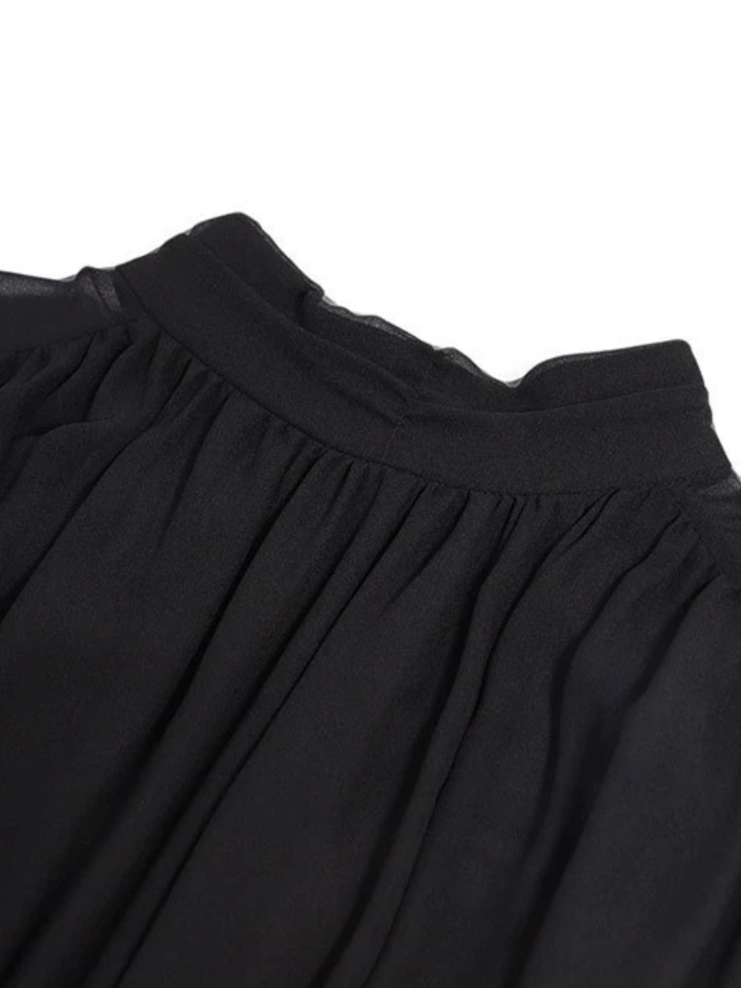 Close up of the neckline detail of black high-neck pleated midi dress