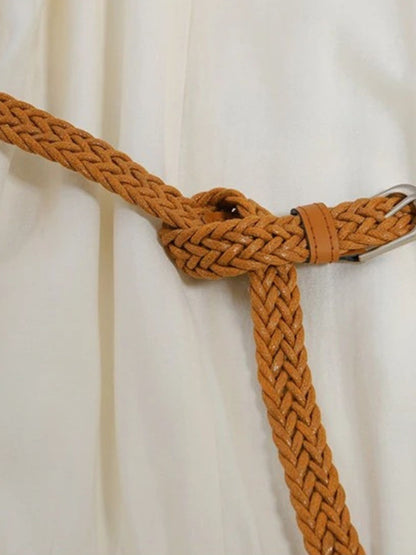 Close up of a brown belt on a cream boho dress
